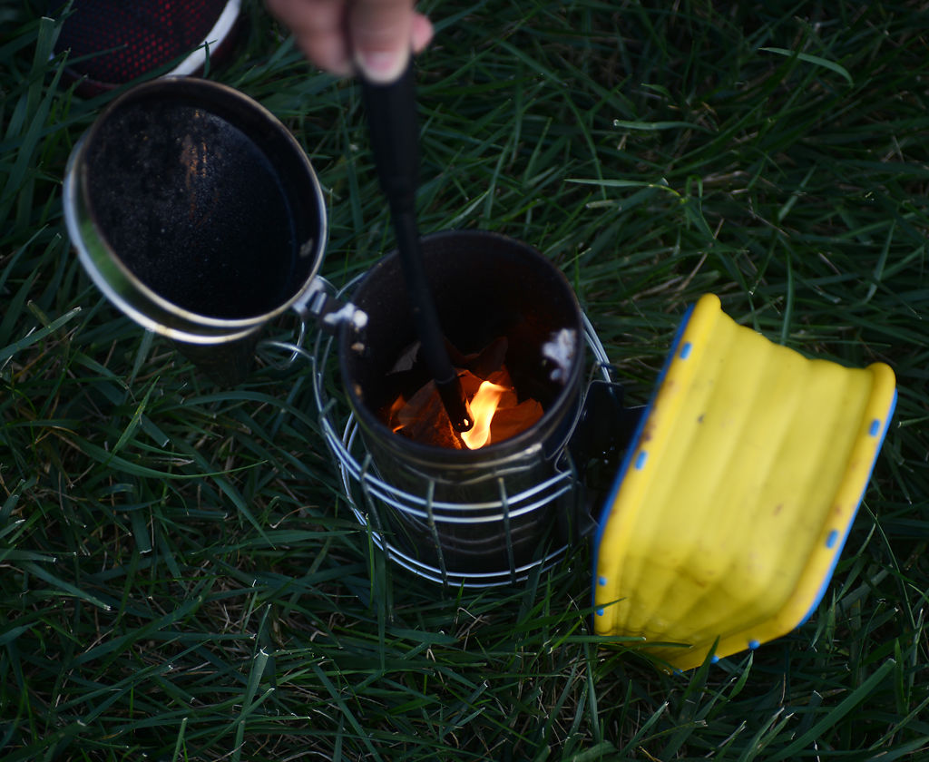 Henry Frees lights up a bee smoker